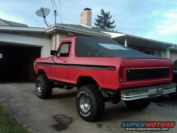 Red 1978 Ford Bronco with a black soft top parked in a driveway