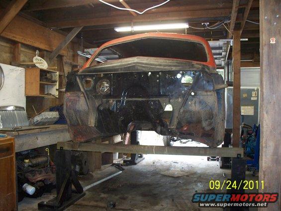 Car body on stands in a workshop, front end disassembled