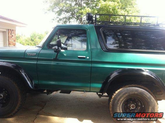 Green 1978 Ford Bronco side view with roof rack and off-road tires