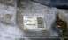 1990 Ford Bronco - A close-up view of a Ford part, possibly from a transmission, with a label containing part numbers and a barcode.