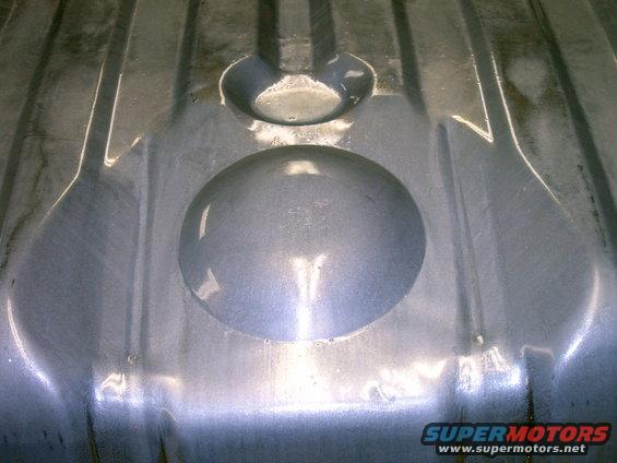Close-up of the interior of a metal fuel tank with embossed circular and oval shapes
