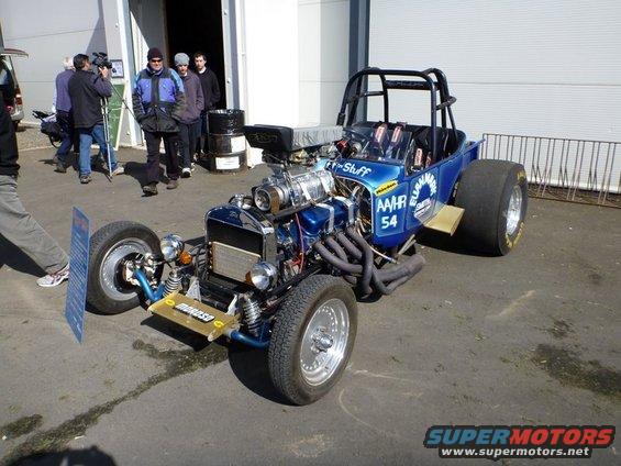 Blue dragster with supercharger, roll cage, and large rear tires. Text on side reads 'AAHR 54'