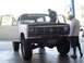 1986 Ford Bronco - Two men are working on a white Ford Bronco with its hood open and doors ajar.