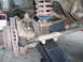 1986 Ford Bronco - Close-up view of heavily rusted vehicle suspension components, including a coil spring and brake rotor.