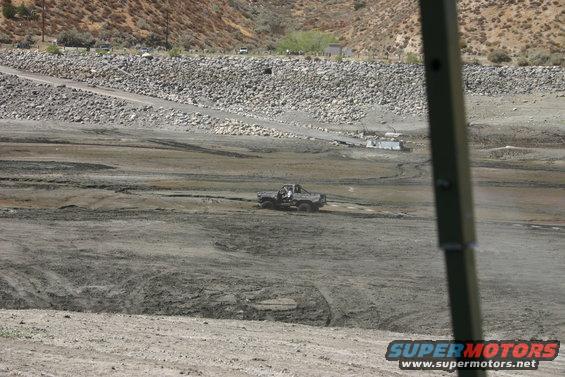 Gray Ford Bronco driving on muddy terrain. The vehicle has a lifted suspension and off-road tires