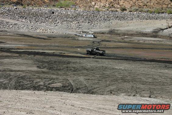 Off-road vehicle driving through a muddy, dry lakebed