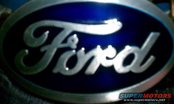 Close-up of a blue oval Ford emblem with silver script lettering