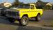 1978 Ford Bronco - Lifted 1978 Ford Bronco with off-road tires sits on a street in front of houses.