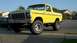 1978 Ford Bronco - This yellow pickup truck has a lifted suspension and large off-road tires.