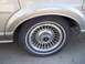 1988 Lincoln Town Car - The intricate design of the 1988 Lincoln Town Car's wheel is visible, a chrome trim and a Lincoln emblem.