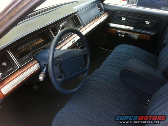 Blue fabric interior with wood trim and dashboard gauges. 1991 Ford Crown Victoria LTD