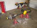 1988 Ford Bronco - Two vehicle axles are supported by red jack stands in a garage setting.