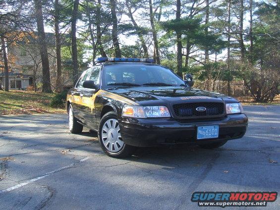 2011 Ford Crown Victoria police car with yellow stripe and "SHERIFF" text on grille