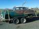 1953 Chevrolet Bel Air - A weathered 1953 Chevrolet Bel Air is transported on a trailer under a clear blue sky.