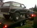 1979 Ford Bronco - A lifted Ford Bronco is loaded onto a trailer, with another vehicle visible behind it.