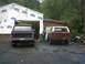 1979 Ford Bronco - Two Ford Broncos are parked outside a garage under construction.