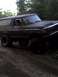 1979 Ford Bronco - This 1979 Ford Bronco is captured in a three-quarter front view, navigating a dirt path surrounded by trees.