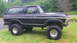 1979 Ford Bronco - Side view of a lifted black 1979 Ford Bronco with off-road tires.