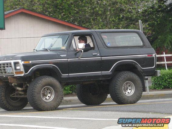 Black Ford Bronco with lifted suspension and large tires, seen from the side
