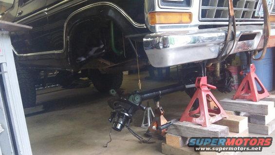 Ford truck on jack stands with front axle removed for repair. Looks like a 1979 model