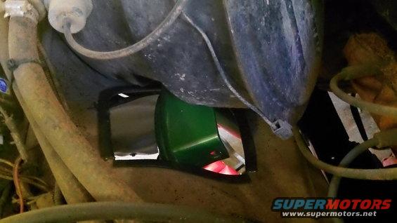 Green painted engine component visible through an opening in the chassis