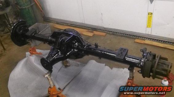 Black heavy-duty rear axle assembly on jack stands, possibly for a truck or large SUV