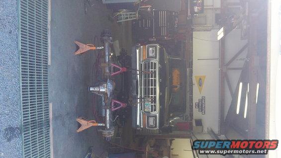 1979 Ford Bronco front end on jack stands, undergoing repairs in a garage