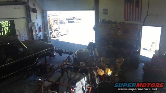 Black 1978 Ford Bronco on jack stands in a garage, front fender and door visible
