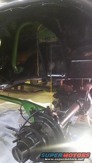Underside view of a vehicle's rear axle and suspension components, possibly during a repair or modification