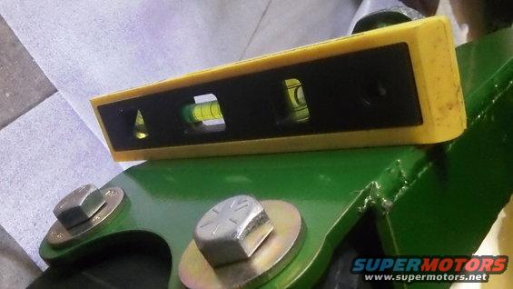 Spirit level on green painted metal with bolts