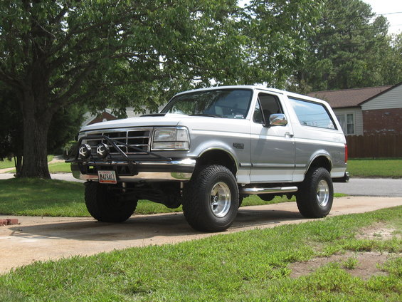 White and silver 1994 Ford Bronco with aftermarket bumper and lights