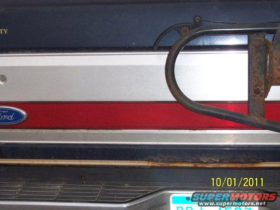 Dark blue rear panel with red stripe and Ford emblem, spare tire mount visible