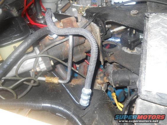 Engine bay with brake lines, hoses, and electrical wiring visible