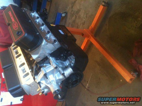 Engine with black valve covers reading "RACING" on an orange engine stand