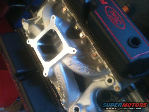 Ford engine intake manifold with Edelbrock branding and black valve cover with red Ford logo