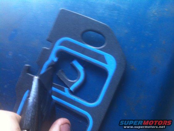 Black gasket with blue sealant, being cut by a utility knife