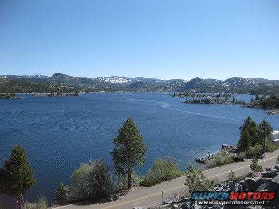 Scenic lake with mountains and trees under a clear blue sky