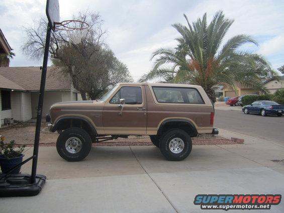 1985 Ford Bronco lifted with aftermarket wheels, parked in driveway