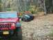 1979 Ford Bronco - Two Jeeps navigate a challenging, leaf-strewn off-road trail during autumn.