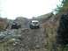 1979 Ford Bronco - Two SUVs navigate a challenging, off-road path through a forest.