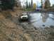 1979 Ford Bronco - A yellow 1978 Ford Bronco navigates a muddy track, kicking up water, with other vehicles visible further down the path.