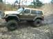 1979 Ford Bronco - This heavily modified Jeep Cherokee XJ is shown navigating a muddy, off-road trail.