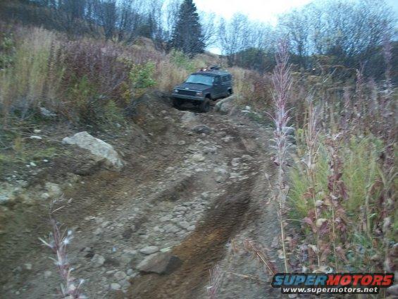 Dark SUV on a rocky, muddy off-road trail