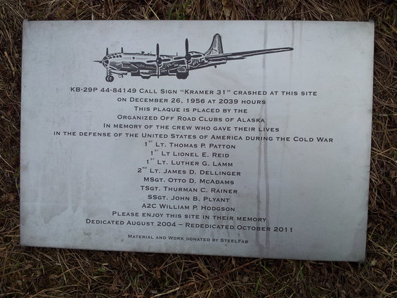Plaque with airplane illustration and text detailing a crash site and memorial