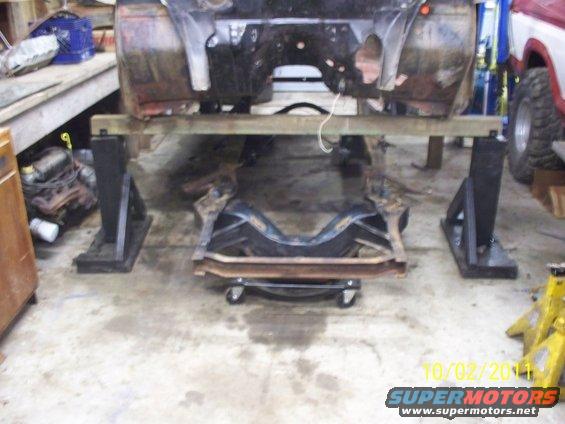 Vehicle frame on stands with suspension removed, in a garage