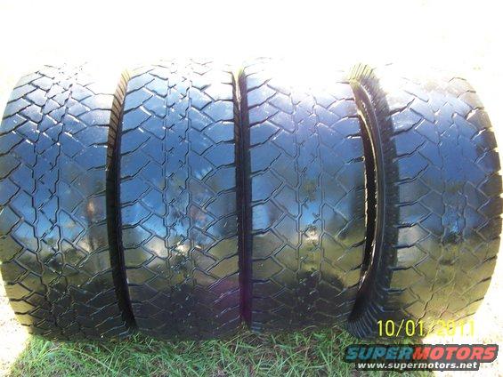 Four off-road tires laid on grass. Date stamp reads 10/01/2011