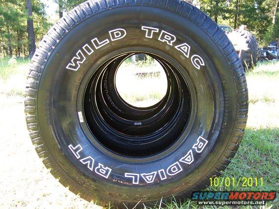 Tires labeled WILD TRAC RADIAL RVT stacked up outside