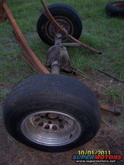 Rear axle assembly with leaf springs and tires on grass