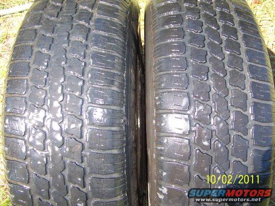 Two used tires, one on the left and one on the right. Date stamp 10/02/2011