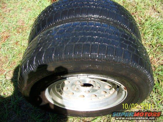 Two tires with rims are on the grass. Text on the tire says "Tiger Paw". Date stamp reads 10/02/2011
